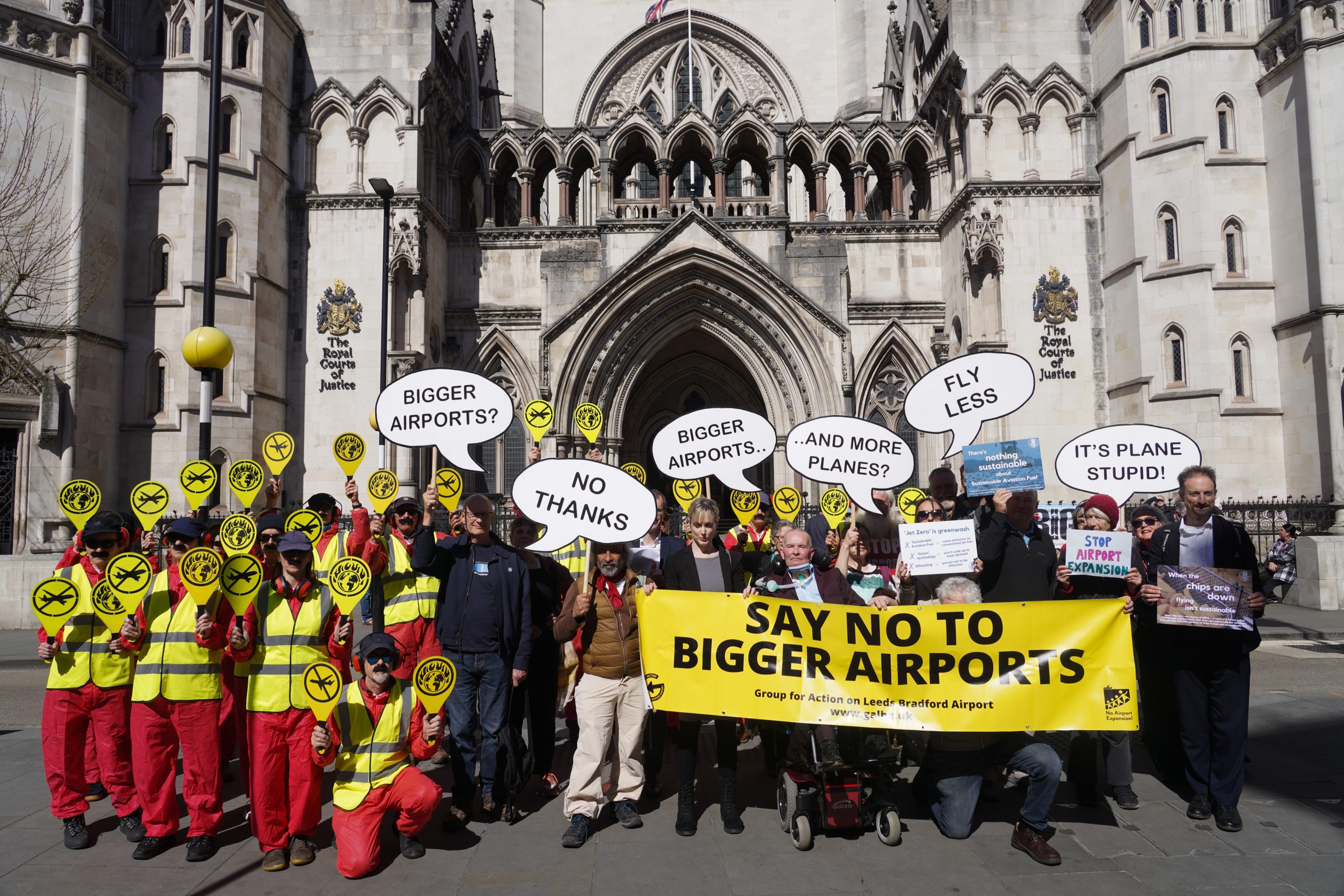 Activists outside the Royal Courts of Justice in London with protesters dressed as aviation workers demanding an end to airport expansions.